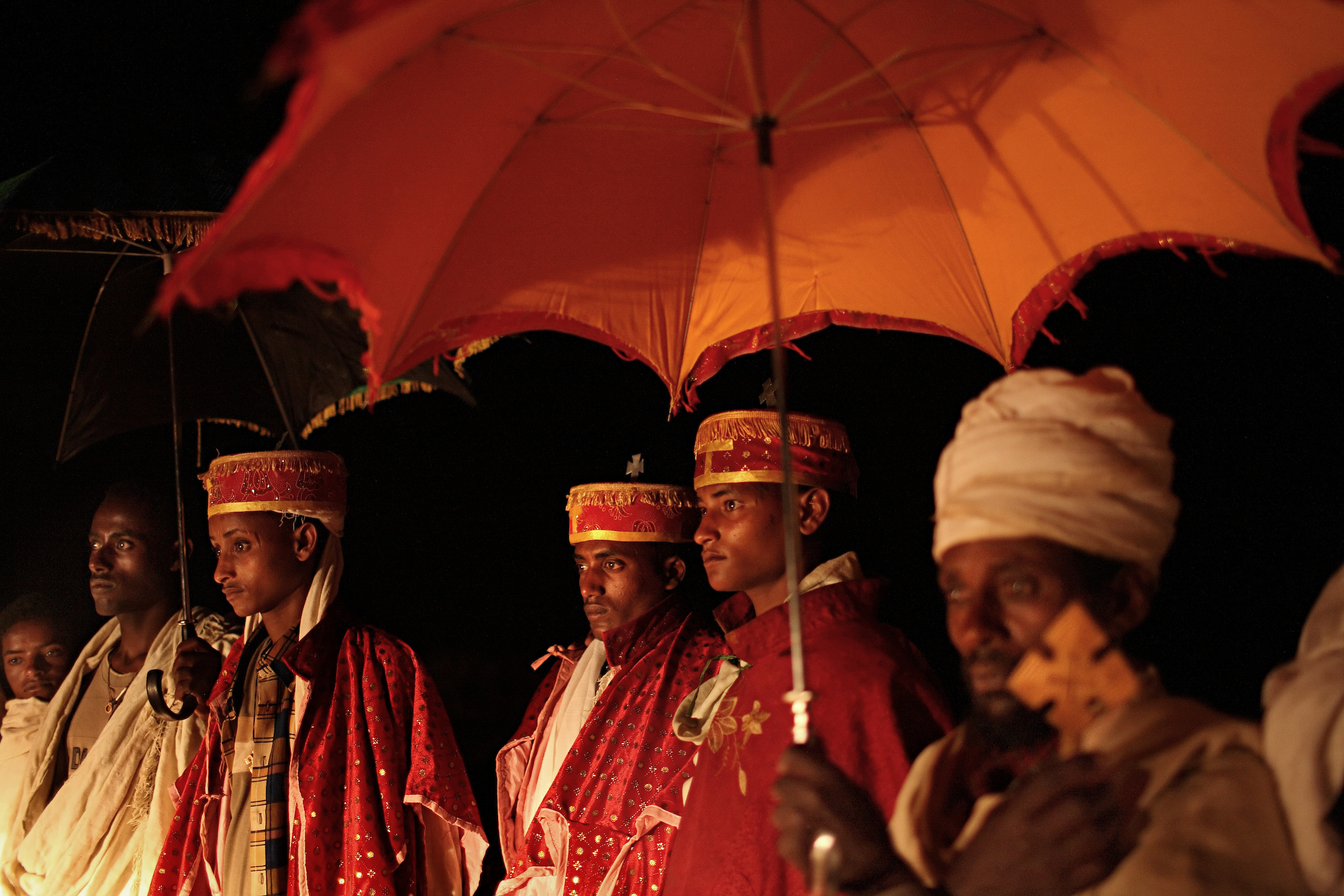 Dressed in traditional Ethiopian Orthodox robes, the wedding party of made up of local priests,including Addisu, 23, walk through the night to pick up his new bride Destaye, 11.